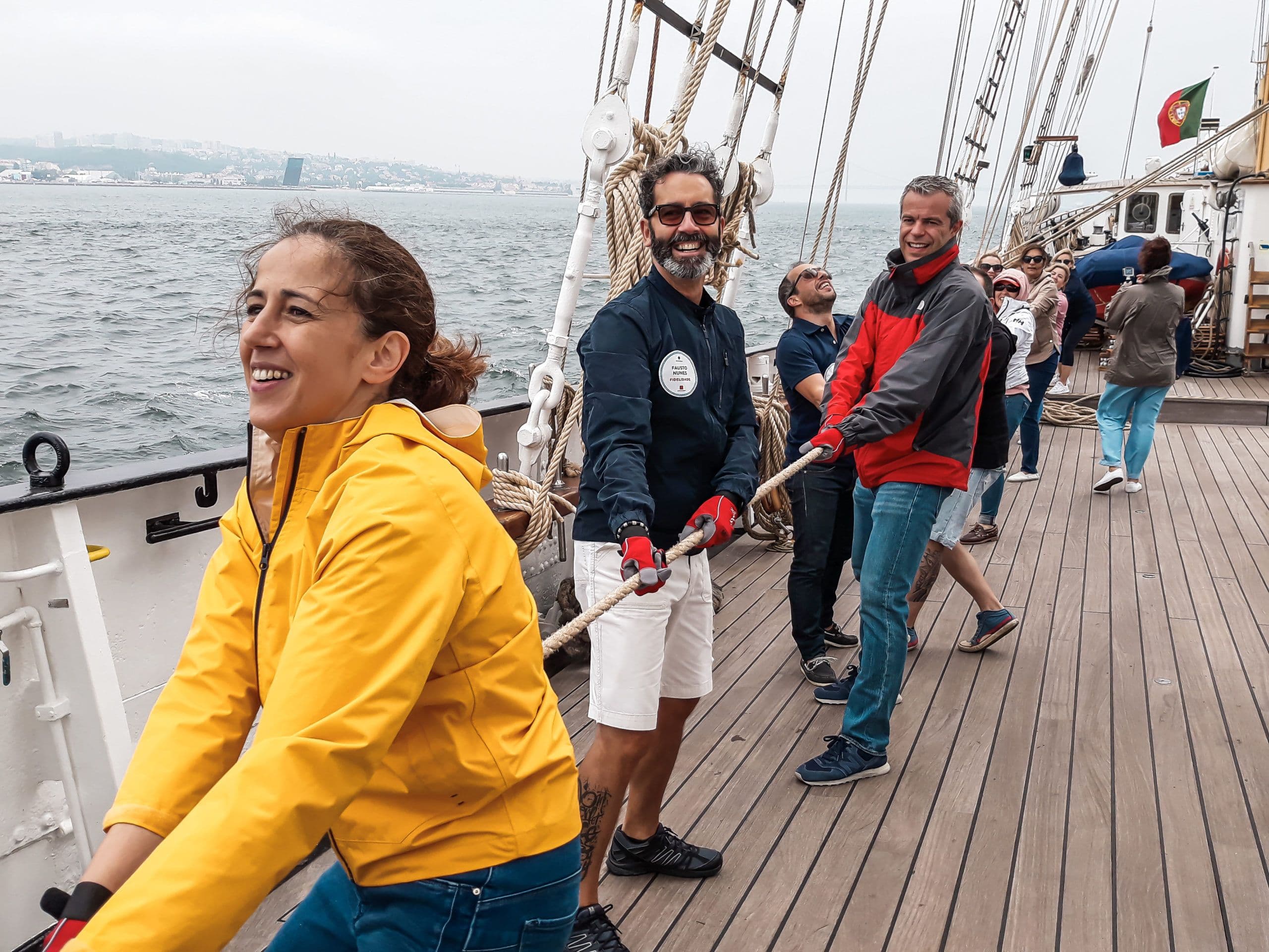 een groep mensen die aan een touw trekken op een zeilboot