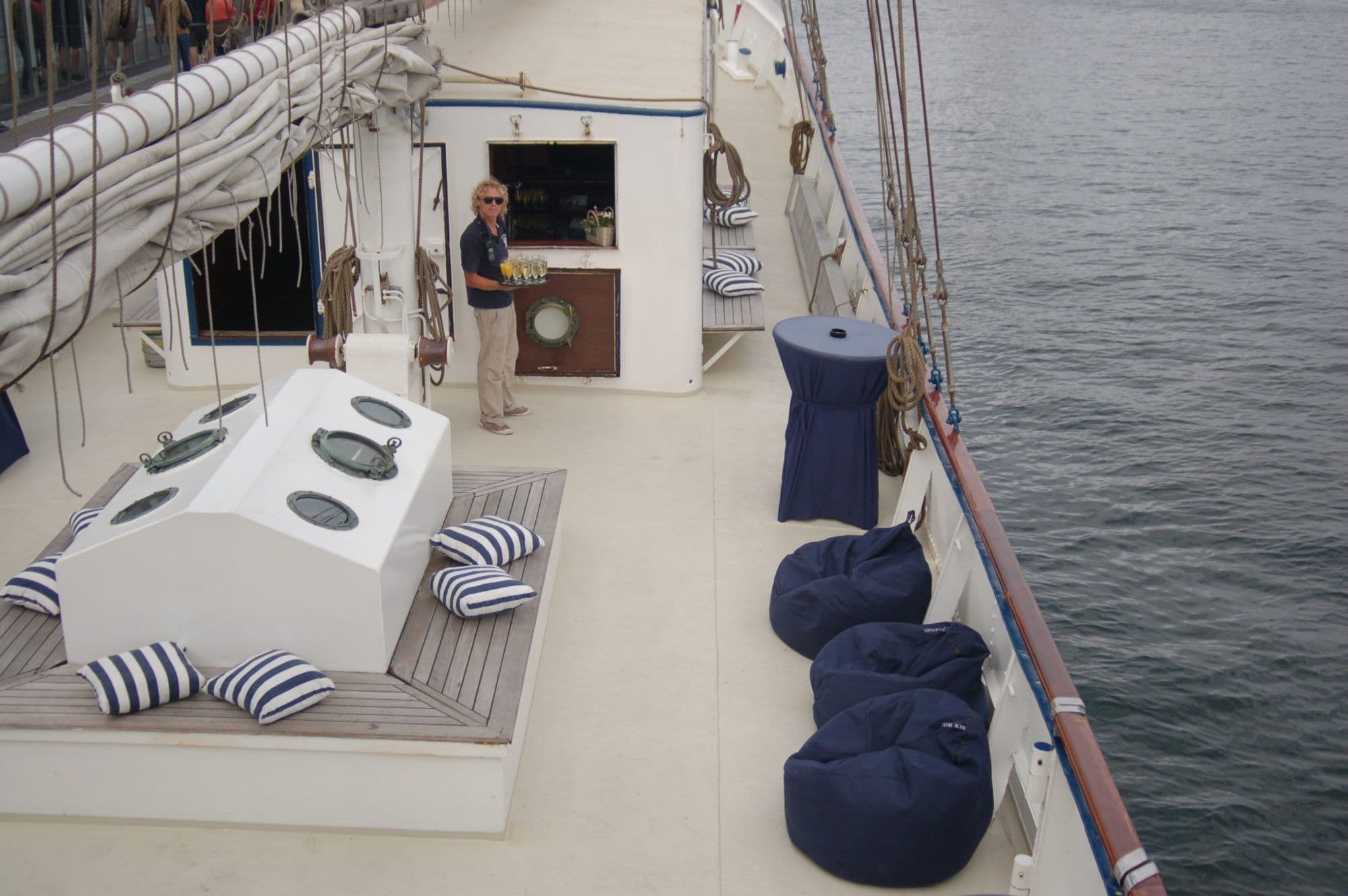 Het dek van de Minerva met een man die een dienblad vasthoudt