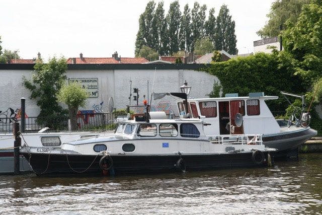 Boot die is aangemeerd naast een andere boot aan de oever - Stichting BASM