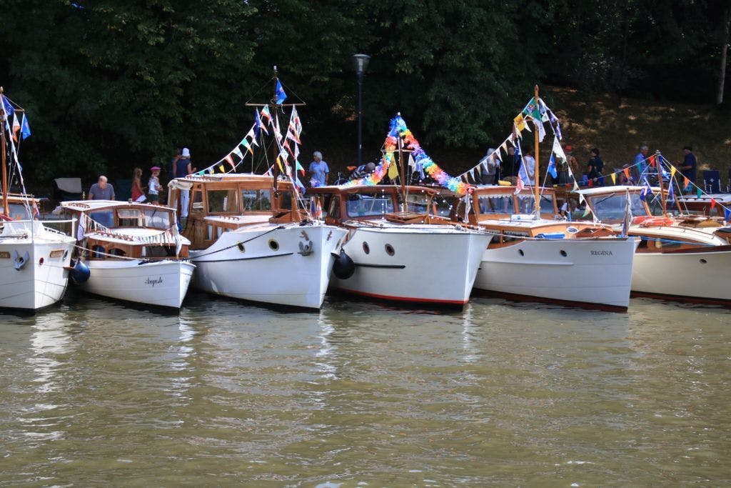 Allemaal dezelfde witte motorboten op een rij aan de kust - Vereniging Oude Glorie