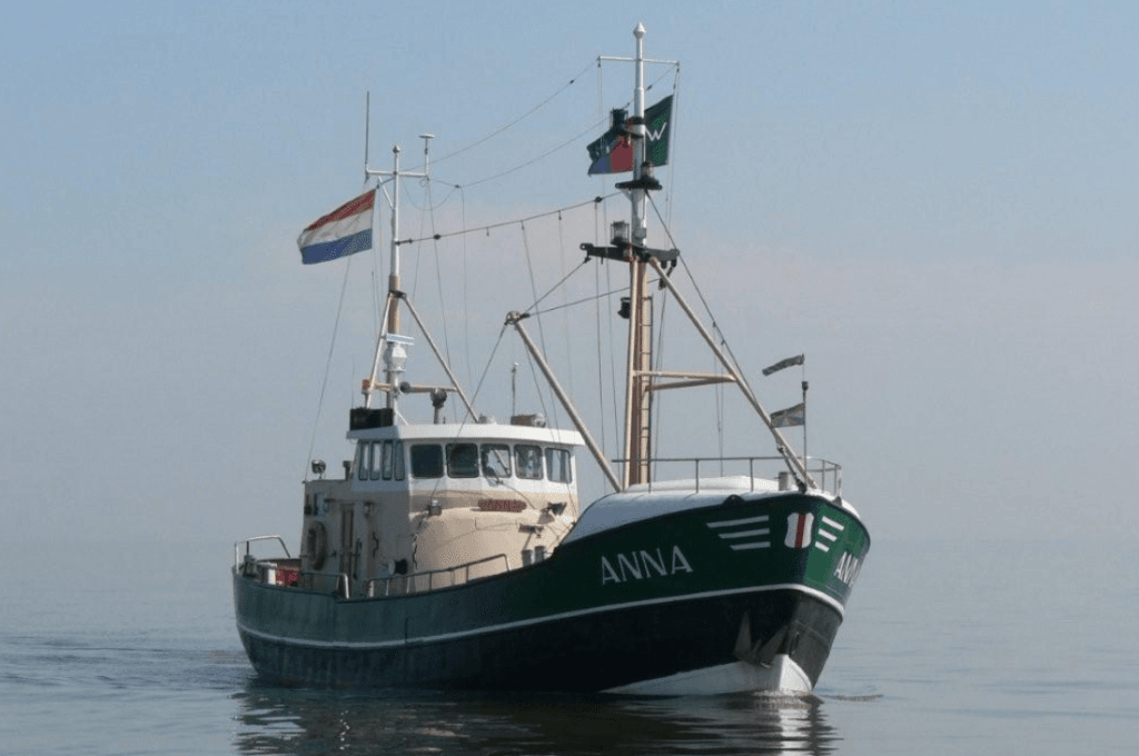 Groene boot Anna met Nederlandse vlag - stichting kotterzeilen en kotterbehoud